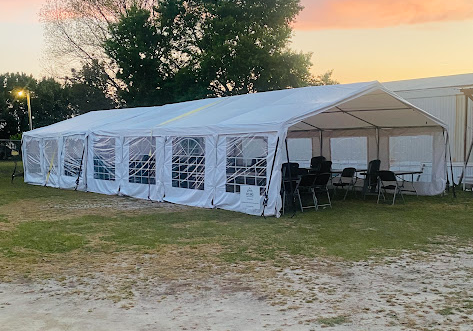 White event tent at sunset with tables and chairs set up